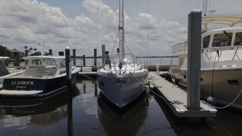 Slide: The Image of 2022 Beneteau Oceanis 40.1 sailboat docked between two motorboats. - 2