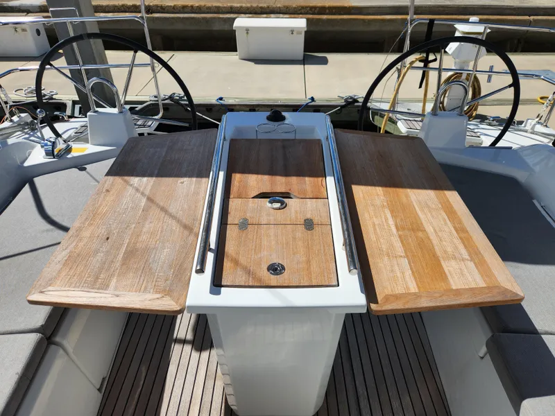 Slide: The Image of Cockpit of 2022 Beneteau Oceanis 40.1 sailboat with wooden table and dual steering wheels. - 25