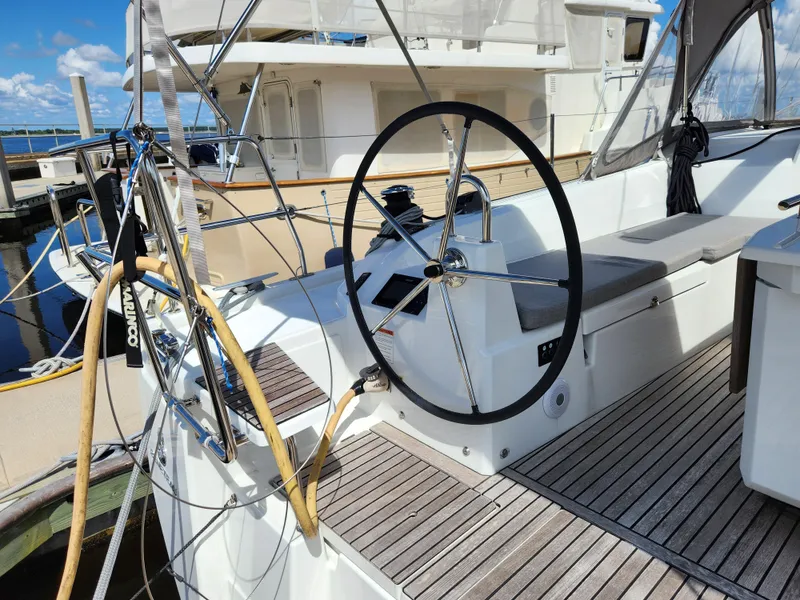 Slide: The Image of 2022 Beneteau Oceanis 40.1 yacht cockpit with steering wheel and seating, docked at marina. - 28