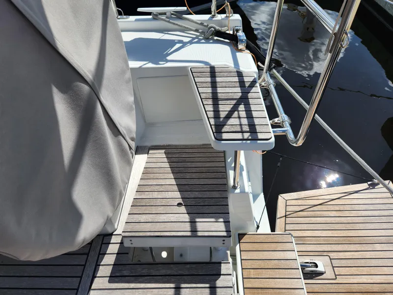 Slide: The Image of Beneteau Oceanis 40.1 yacht deck, 2022 model, featuring wooden steps and stainless steel railings. - 32