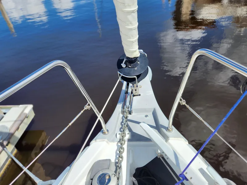 Slide: The Image of Bow of 2022 Beneteau Oceanis 40.1 sailboat with anchor chain and calm water reflection. - 40