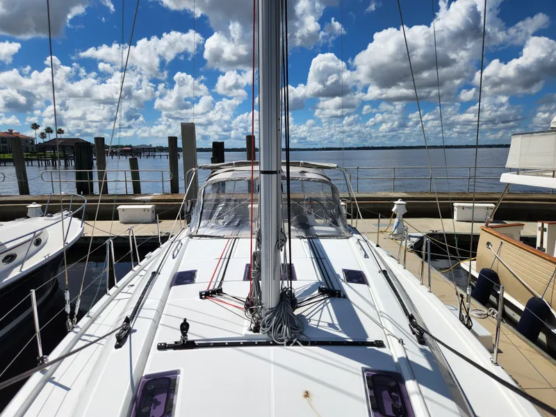 Slide: The Image of 2022 Beneteau Oceanis 40.1 sailboat docked under a vibrant blue sky with clouds. - 48