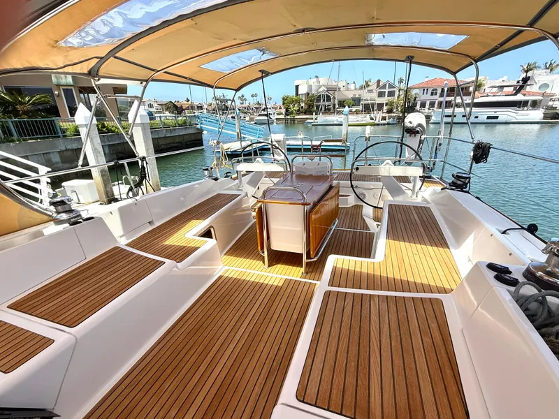 Slide: The Image of Spacious deck of 2018 Jeanneau 58 yacht with elegant wood finish and marina view. - 1