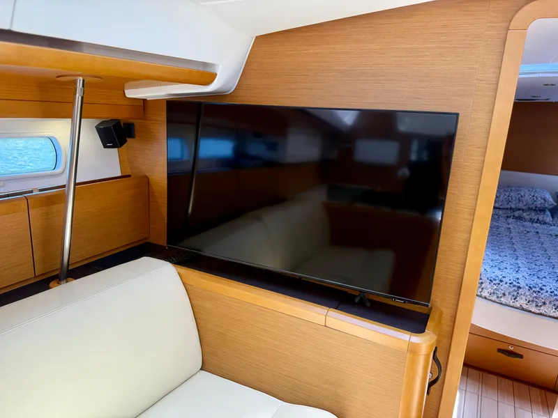 Slide: The Image of Interior of 2018 Jeanneau 58 yacht with modern TV and cozy seating area. - 14