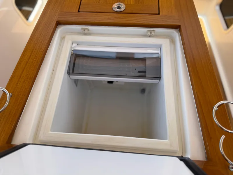 Slide: The Image of Open storage compartment on 2018 Jeanneau 58 yacht with wooden trim. - 21