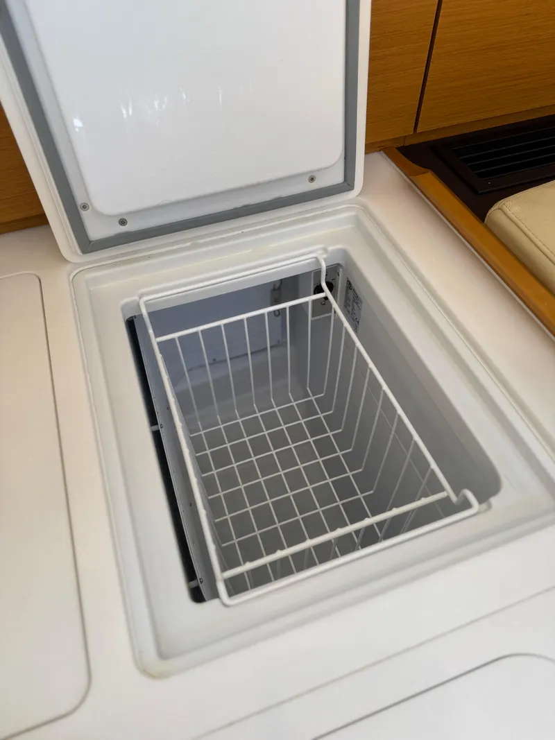 Slide: The Image of Open storage compartment on 2018 Jeanneau 58 yacht, featuring a wire basket. - 32