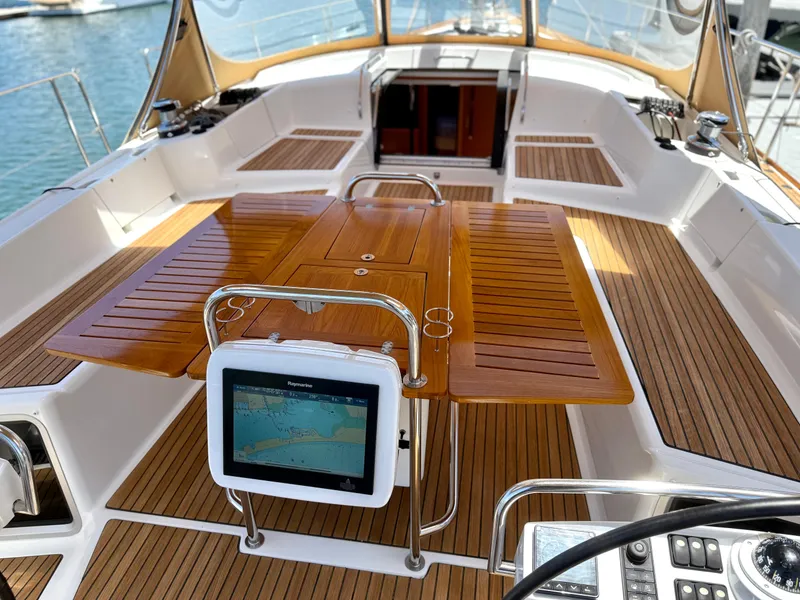 Slide: The Image of Cockpit of 2018 Jeanneau 58 yacht with wooden table and navigation display. - 34