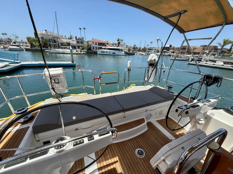 Slide: The Image of 2018 Jeanneau 58 yacht cockpit with dual steering wheels in a marina setting. - 36