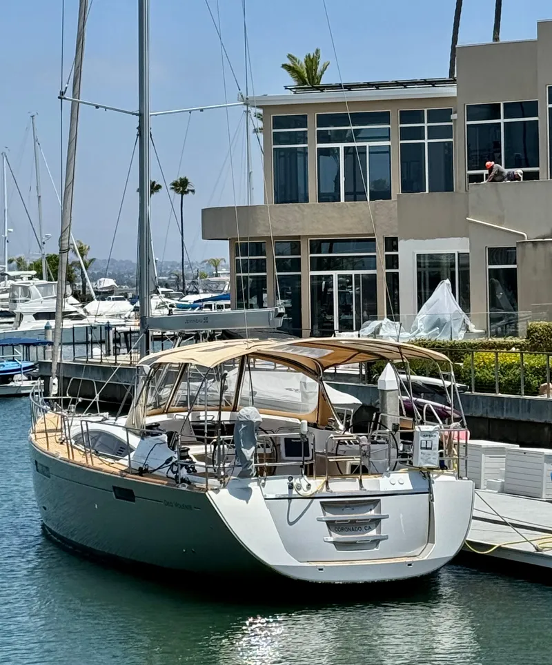 Slide: The Image of 2018 Jeanneau 58 yacht docked at marina, modern building in background. - 45
