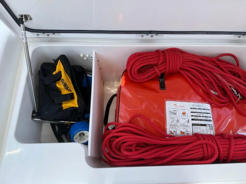 Slide: The Image of Storage compartment on a 2018 Jeanneau 58 yacht with red ropes and a tool bag. - 50