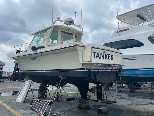 Slide: The Image of 2001 Albin 31' Tournament Express boat on dry dock, named "Tanker," in a marina setting. - 18