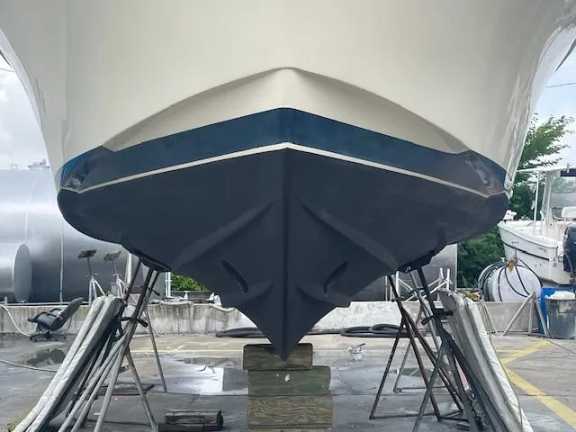 Slide: The Image of 2001 Albin 31' Tournament Express boat hull on stands in a shipyard. - 19