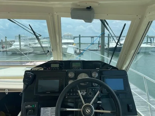 Slide: The Image of Helm of 2001 Albin 31' Tournament Express at marina, featuring navigation equipment and steering wheel. - 7