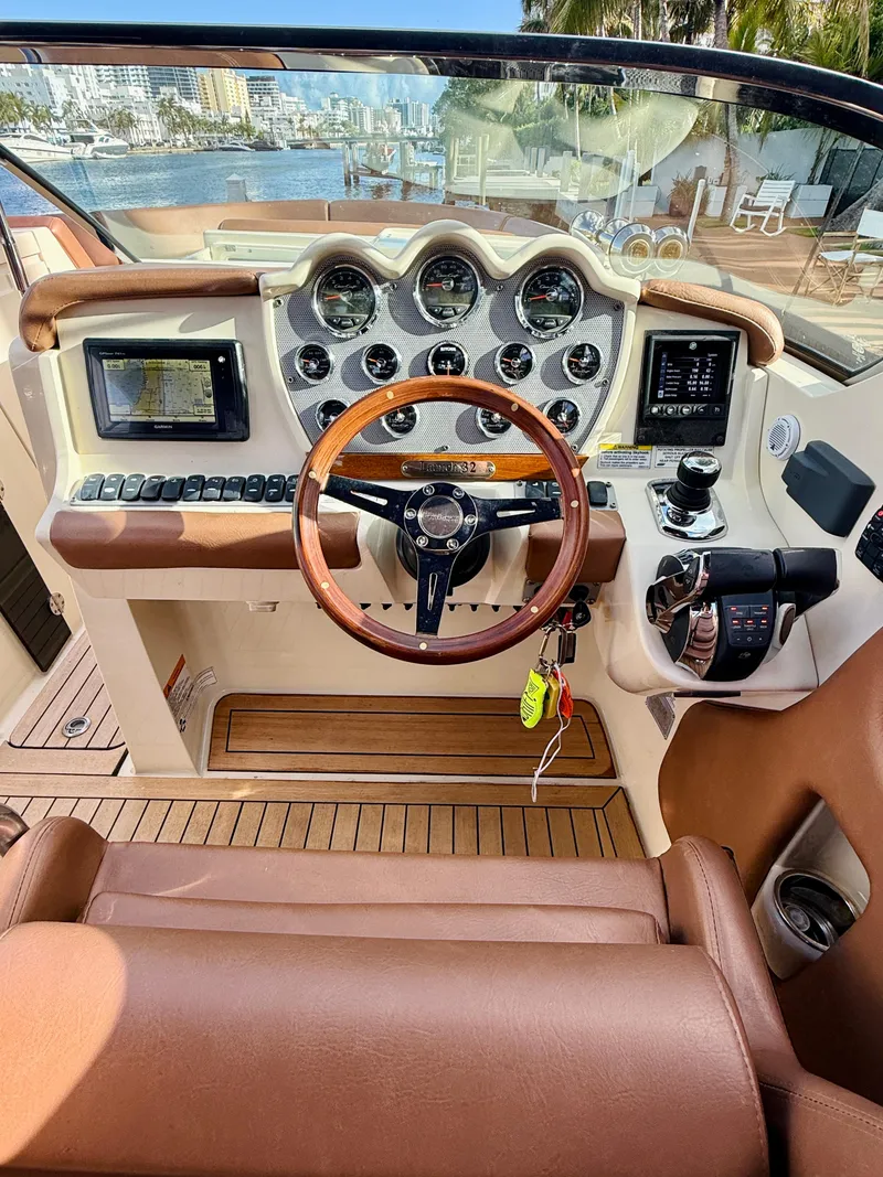 Slide: The Image of 2015 Chris-Craft Launch 32 dashboard with wooden steering wheel and modern controls. - 7