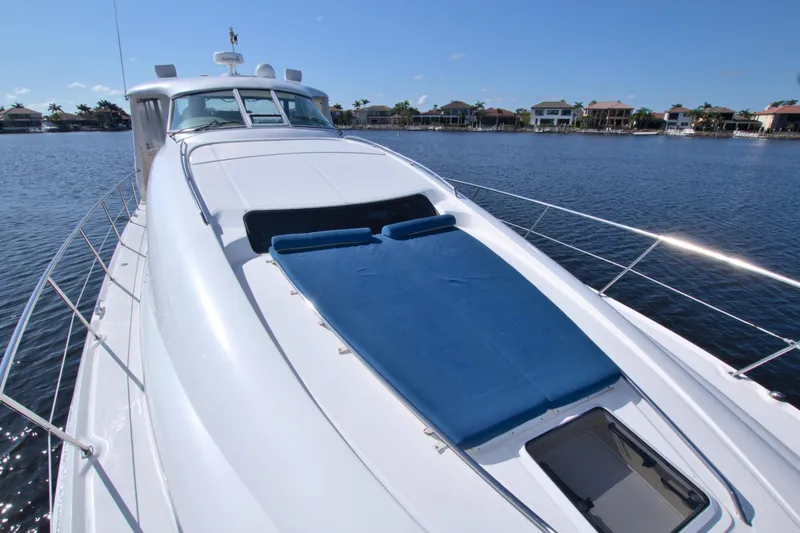Slide: The Image of 2003 Sea Ray 480 Motor Yacht on calm water, featuring a spacious deck and blue sunbed. - 14