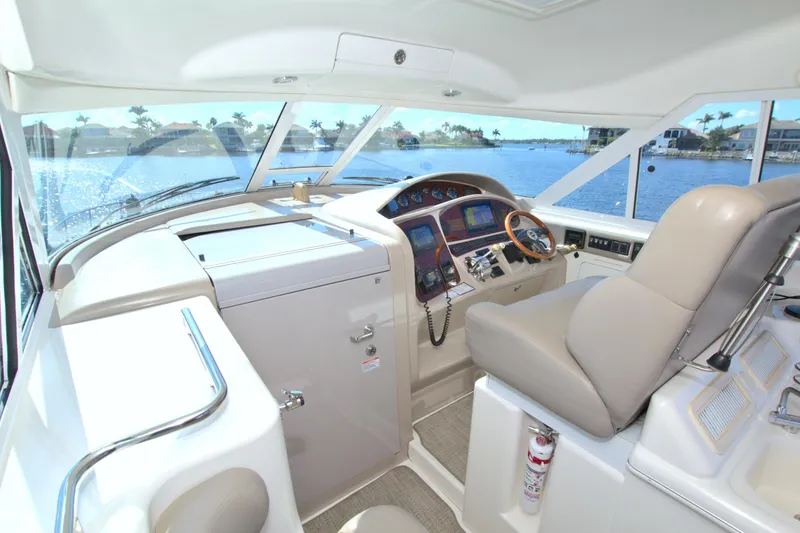 Slide: The Image of 2003 Sea Ray 480 Motor Yacht helm with navigation controls and waterfront view. - 24