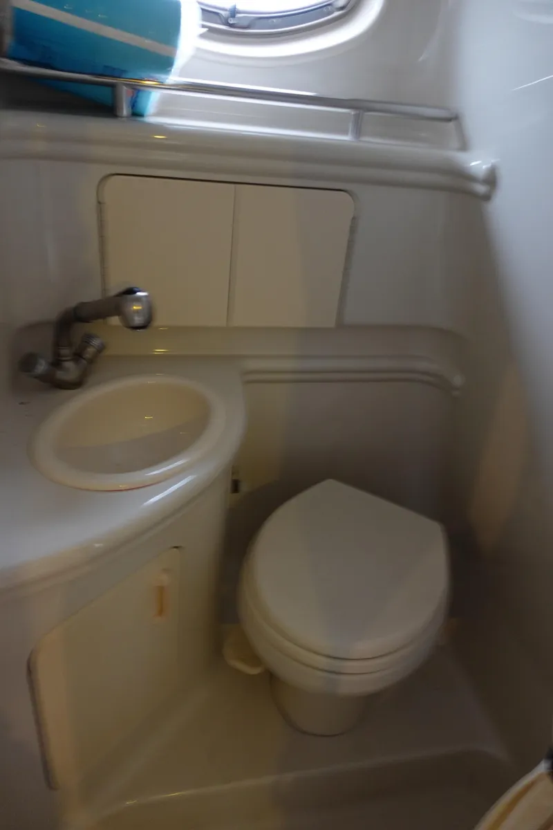 Slide: The Image of 2007 Sea Ray 280 Sundancer bathroom with sink, toilet, and porthole window. - 16