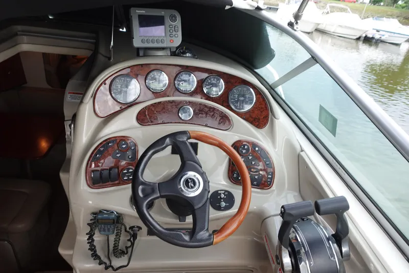 Slide: The Image of 2007 Sea Ray 280 Sundancer helm with wood accents and modern controls. - 4