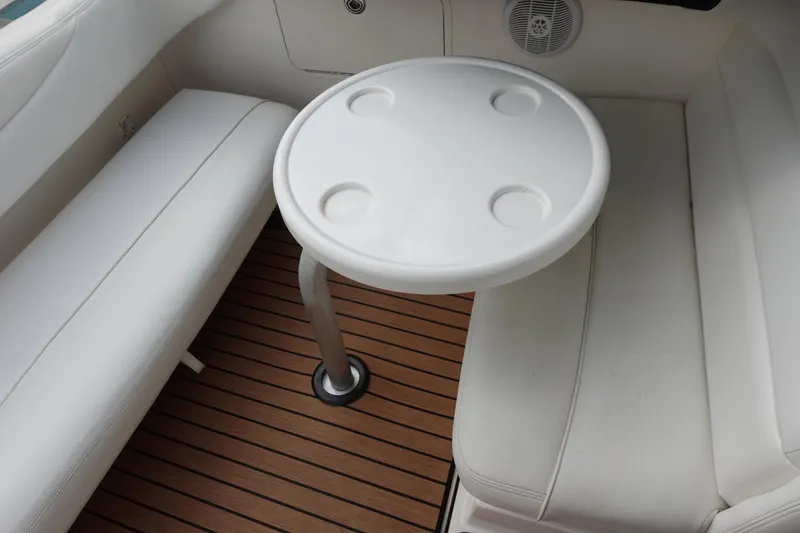 Slide: The Image of Interior seating area of 2007 Sea Ray 280 Sundancer with round table and cushioned benches. - 8