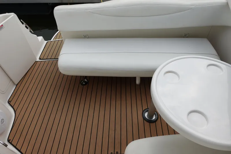 Slide: The Image of 2007 Sea Ray 280 Sundancer interior with white seating and wooden deck flooring. - 9