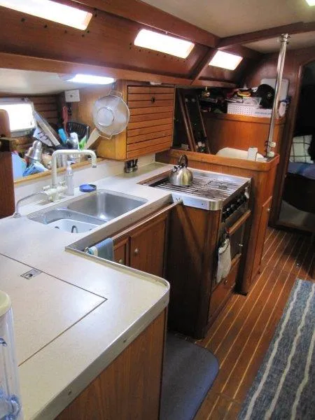 Slide: The Image of Interior of 1990 Jeanneau Sun Magic 44 yacht with kitchen and wooden cabinetry. - 13