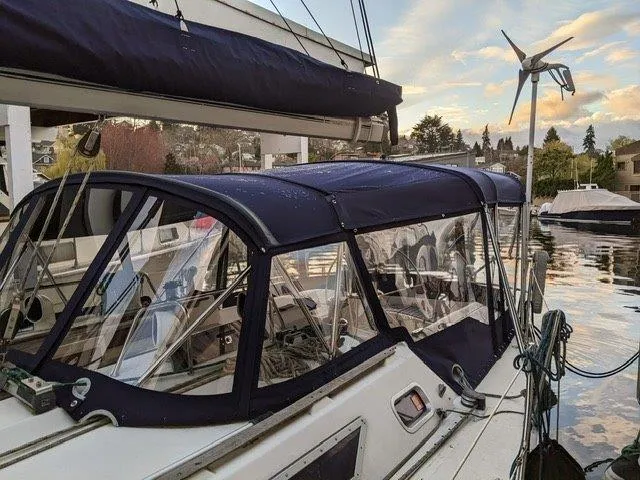 Slide: The Image of Jeanneau Sun Magic 44 sailboat, 1990 model, docked with blue canopy and serene waterfront view. - 19