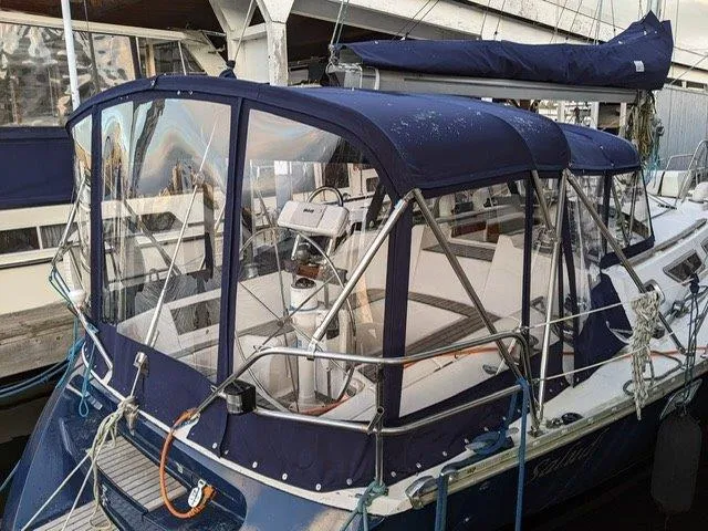 Slide: The Image of Jeanneau Sun Magic 44 sailboat, 1990 model, docked with blue canopy and visible steering wheel. - 20
