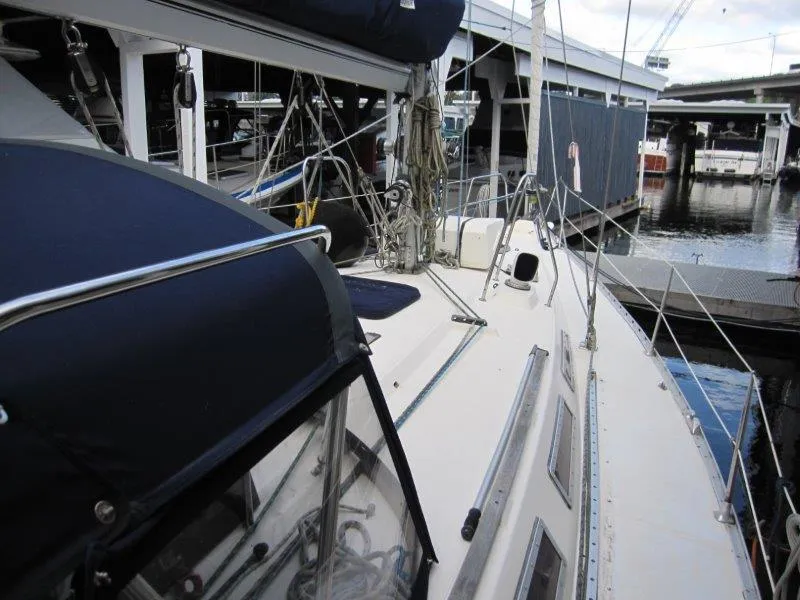 Slide: The Image of 1990 Jeanneau Sun Magic 44 sailboat docked at marina, showcasing deck and rigging. - 28