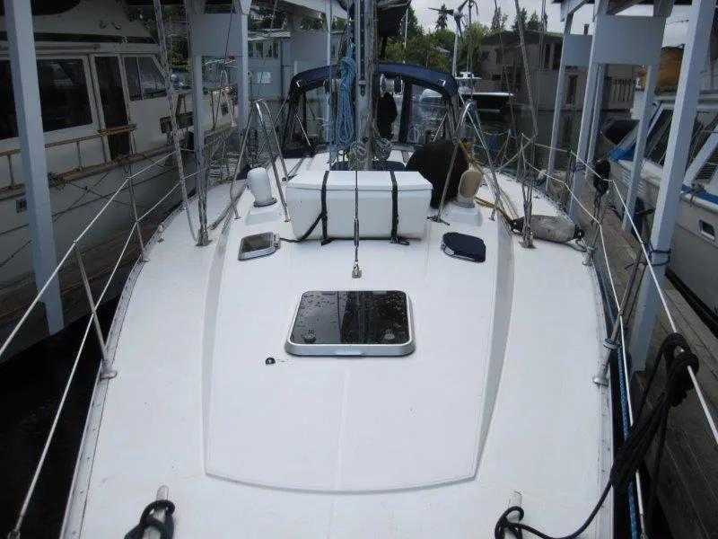 Slide: The Image of 1990 Jeanneau Sun Magic 44 sailboat deck, docked, with visible rigging and hatch. - 31