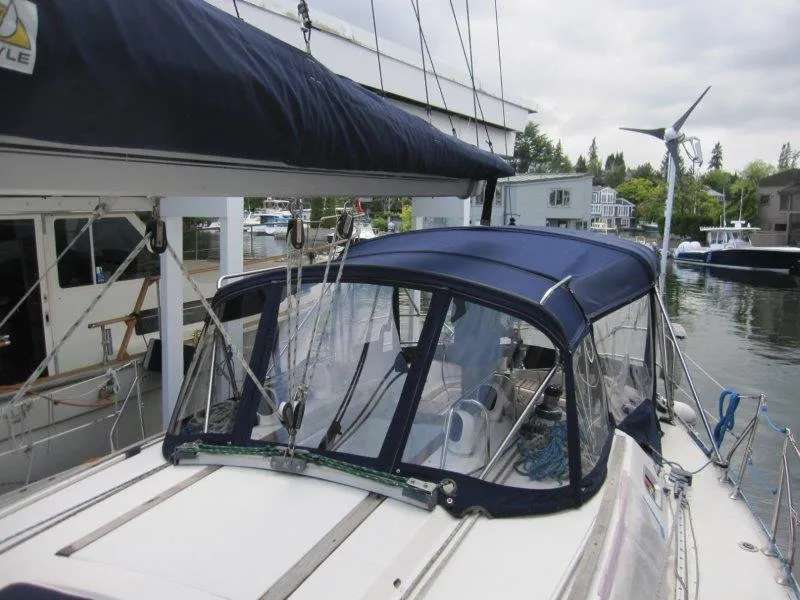 Slide: The Image of 1990 Jeanneau Sun Magic 44 sailboat with blue canopy docked in marina. - 32