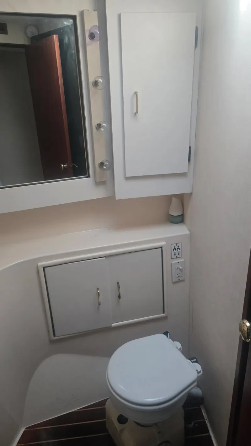 Slide: The Image of 1984 Ocean Yachts 46 Super Sport illuminated in blue at night, docked in a marina. - 10