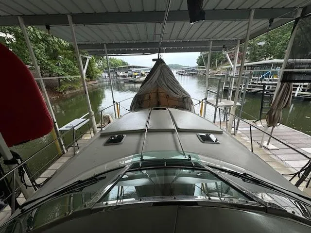 Slide: The Image of 1999 Sea Ray 38' Sundancer docked under a covered marina, surrounded by calm waters and greenery. - 10