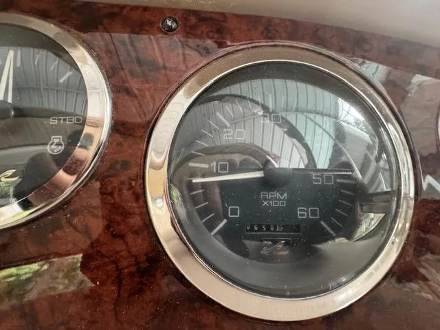 Slide: The Image of Dashboard of 1999 Sea Ray 38' Sundancer showing RPM gauge and wood finish. - 14