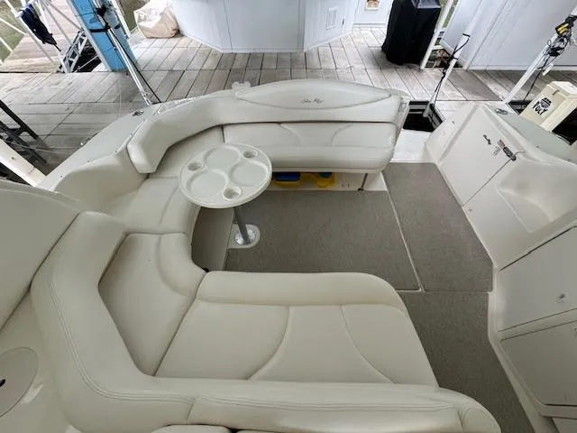 Slide: The Image of 1999 Sea Ray 38' Sundancer interior with white seating and round table on deck. - 17