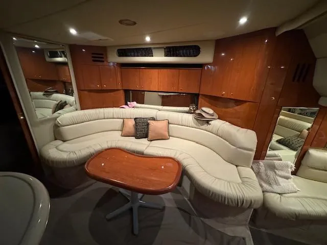 Slide: The Image of Luxurious interior of 1999 Sea Ray 38' Sundancer yacht with plush seating and wooden table. - 33