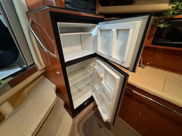 Slide: The Image of 1999 Sea Ray 38' Sundancer yacht interior with open refrigerator in kitchen area. - 35