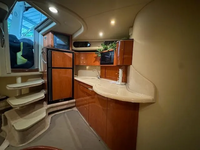 Slide: The Image of Interior of a 1999 Sea Ray 38' Sundancer yacht with modern kitchen and wooden cabinetry. - 36