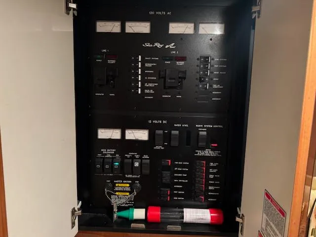 Slide: The Image of Electrical panel of a 1999 Sea Ray 38' Sundancer boat, featuring AC and DC controls. - 45