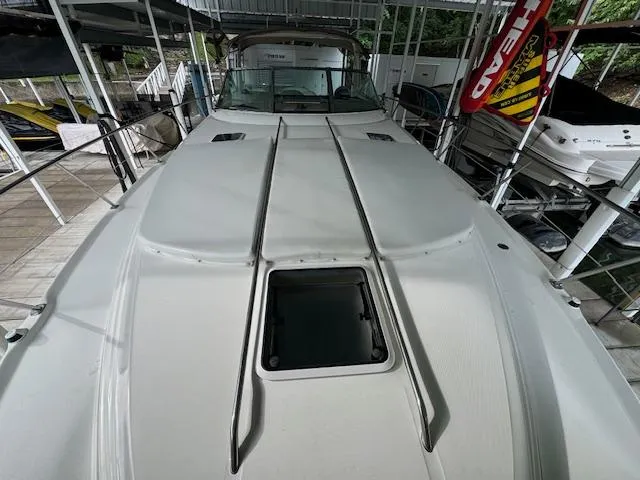 Slide: The Image of 1999 Sea Ray 38' Sundancer yacht docked, showcasing sleek deck design and open hatch. - 9