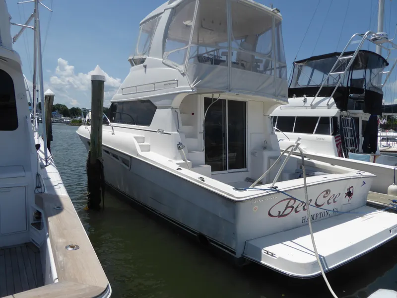Slide: The Image of 2000 Silverton 42C Cummins yacht docked at marina under clear sky. - 1