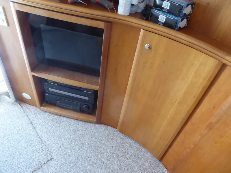 Slide: The Image of Wooden cabinet with TV and stereo system in 2000 Silverton 42C Cummins yacht interior. - 19