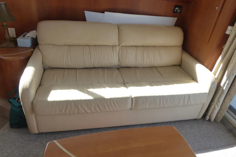 Slide: The Image of Beige leather sofa inside 2000 Silverton 42C Cummins yacht, with wooden interior accents. - 20