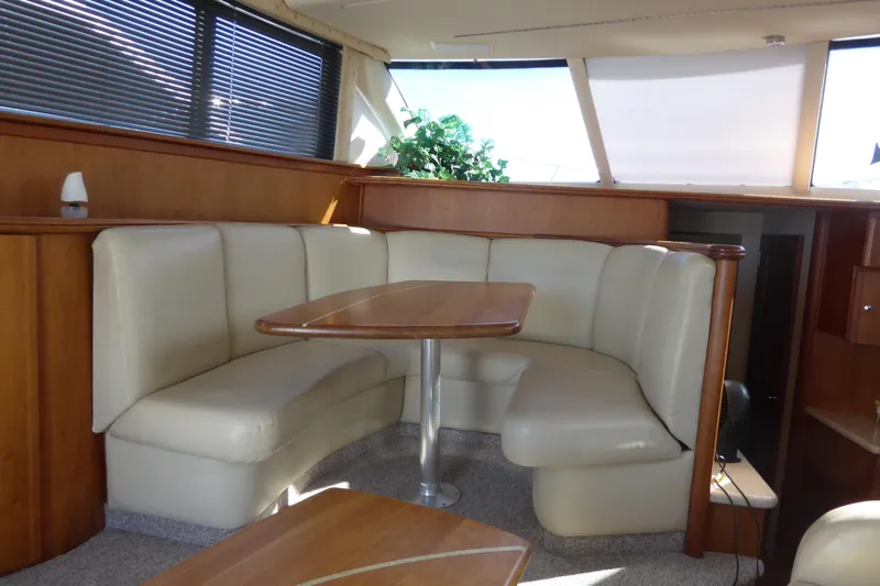 Slide: The Image of Luxurious interior of 2000 Silverton 42C yacht with leather seating and wooden table. - 21