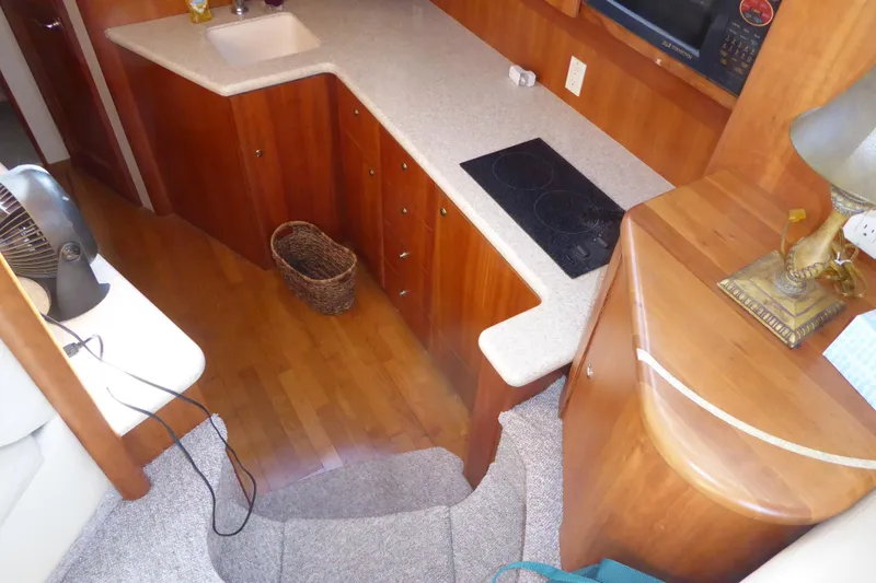 Slide: The Image of Interior of 2000 Silverton 42C yacht with wooden cabinetry and modern kitchen amenities. - 25