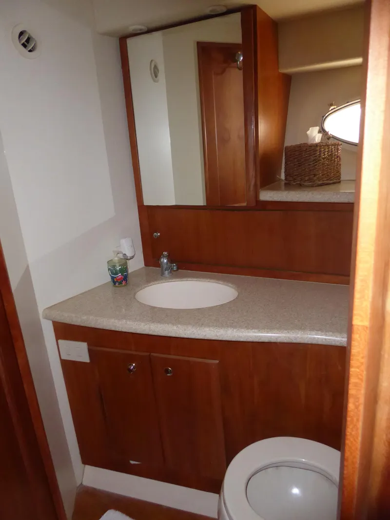 Slide: The Image of Bathroom interior of 2000 Silverton 42C yacht, featuring wooden cabinetry and modern fixtures. - 35