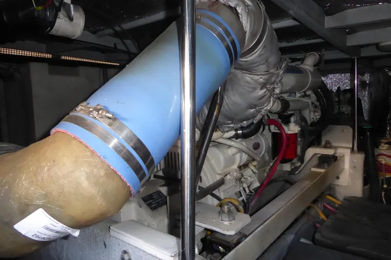 Slide: The Image of Engine compartment of 2000 Silverton 42C with Cummins 450 Diesels, featuring blue exhaust pipe. - 38