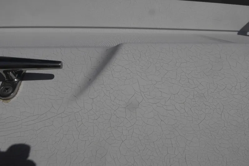 Slide: The Image of Cracked paint on 2000 Silverton 42C Cummins 450 Diesels boat surface with metal cleat. - 16