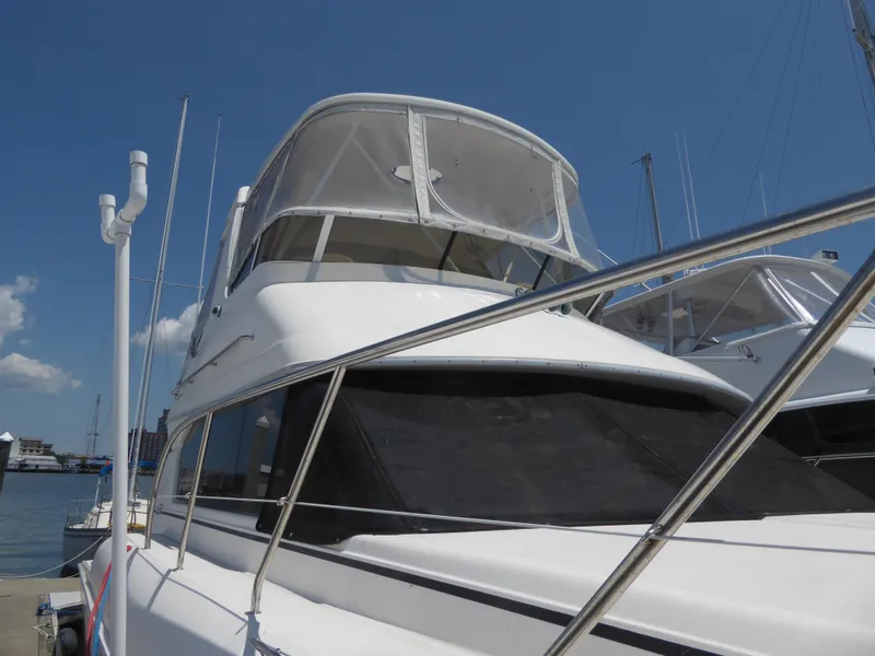 Slide: The Image of 2000 Silverton 42C Cummins 450 Diesels yacht docked under clear blue sky. - 2