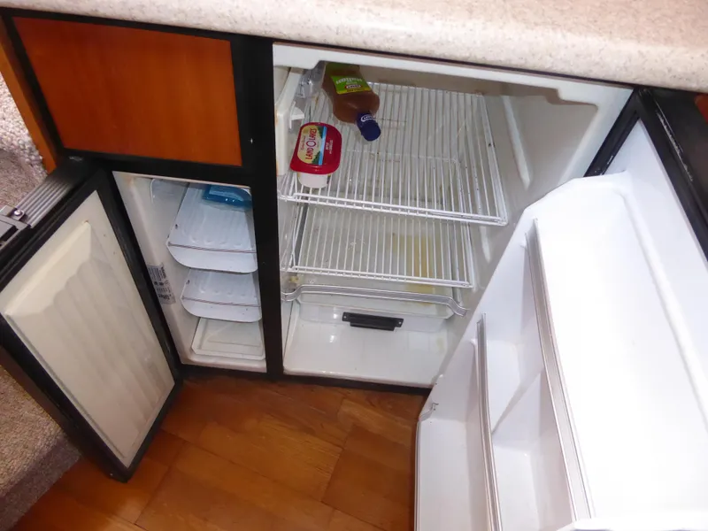 Slide: The Image of Open refrigerator in 2000 Silverton 42C Cummins yacht, showing interior shelves and condiments. - 29