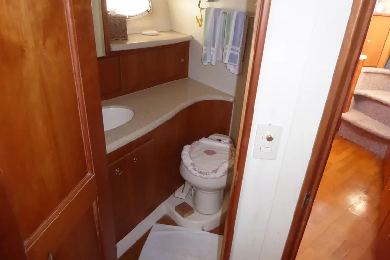 Slide: The Image of Bathroom interior of 2000 Silverton 42C Cummins yacht, featuring wooden cabinetry and compact design. - 36